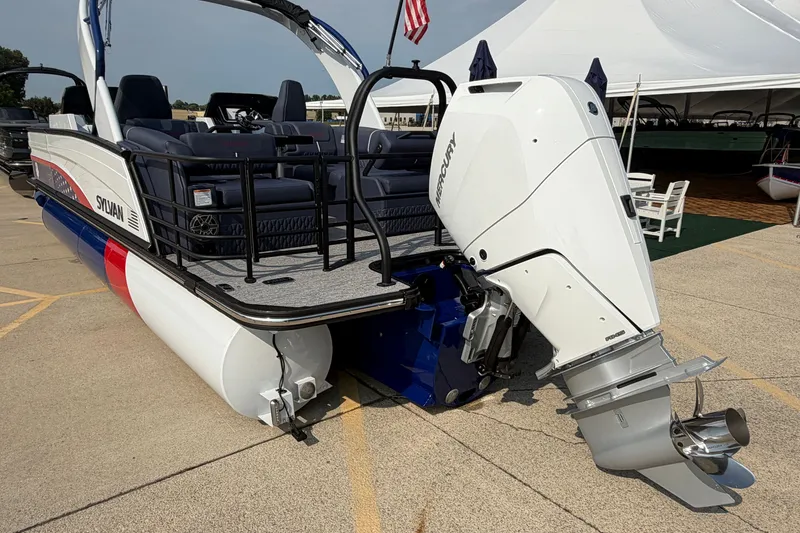 Slide: The Image of 2027 Sylvan G5 LZ DC pontoon boat with Mercury outboard motor, docked near a tent. - 5
