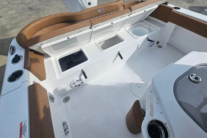 Slide: The Image of 2027 Sea Hunt Ultra 239 SE boat interior with seating, storage, and cup holders. - 12