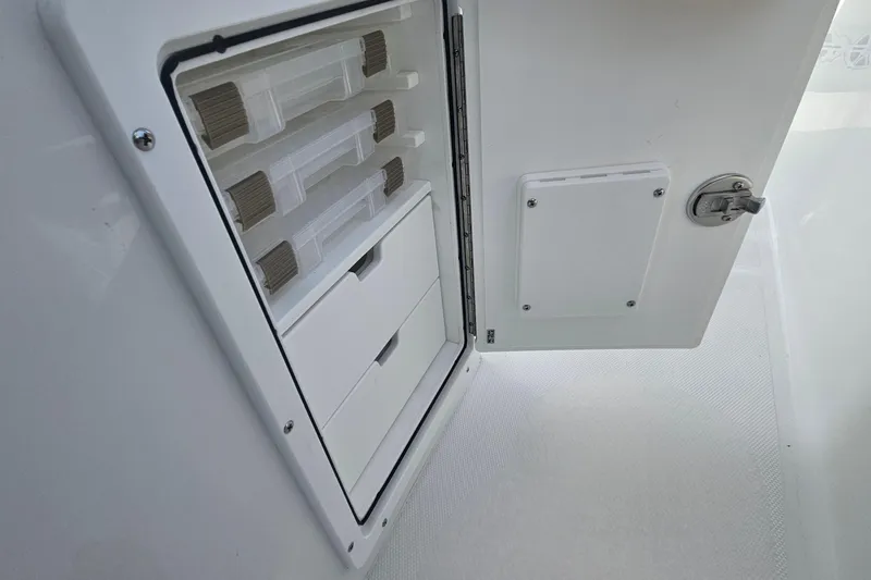 Slide: The Image of Storage compartment on a 2027 Sea Hunt Ultra 239 SE boat, featuring organized drawers. - 20