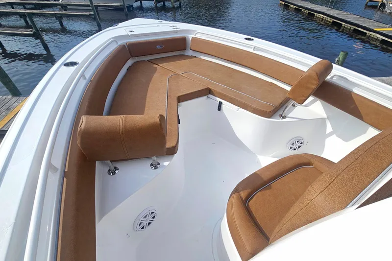 Slide: The Image of 2027 Sea Hunt Ultra 239 SE boat interior with brown seating, docked by the water. - 23