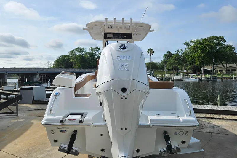 Slide: The Image of 2027 Sea Hunt Ultra 239 SE boat with Yamaha 300 V6 engine docked by a scenic waterfront. - 7