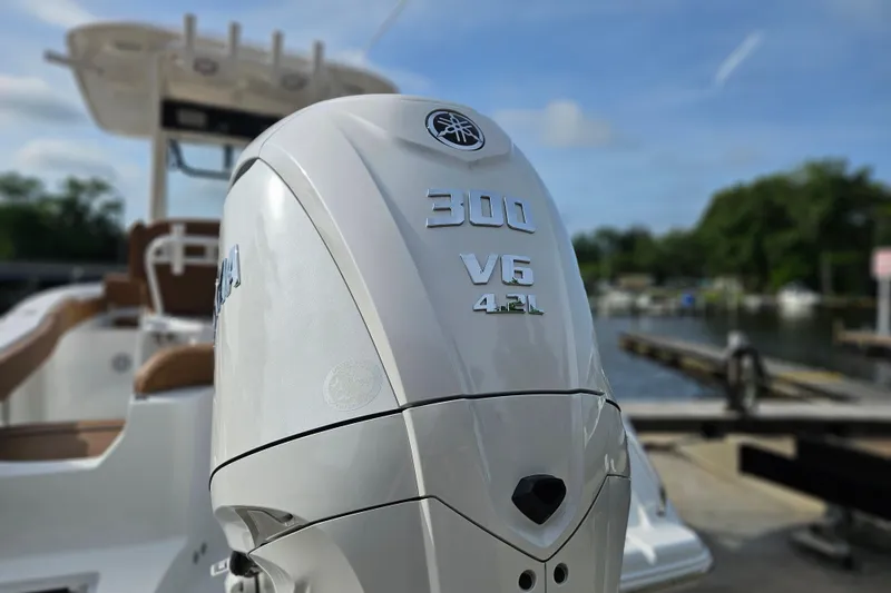 Slide: The Image of Outboard motor on a 2027 Sea Hunt Ultra 239 SE boat, docked by the water. - 6