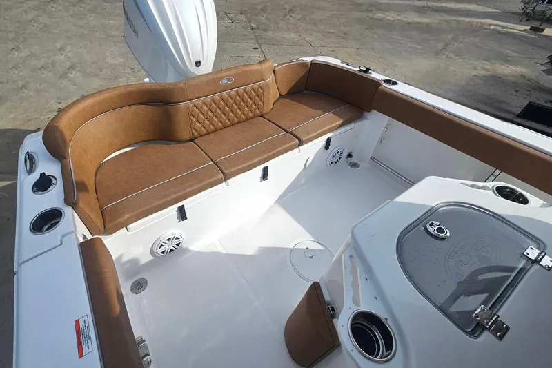 Slide: The Image of 2027 Sea Hunt Ultra 239 SE boat interior with brown seating and modern amenities. - 11