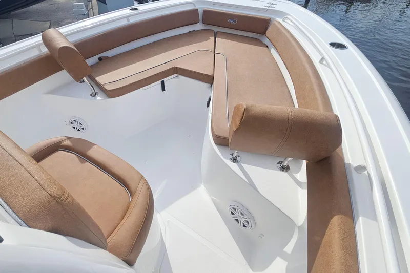 Slide: The Image of 2027 Sea Hunt Ultra 239 SE boat interior with tan seating and white deck. - 24