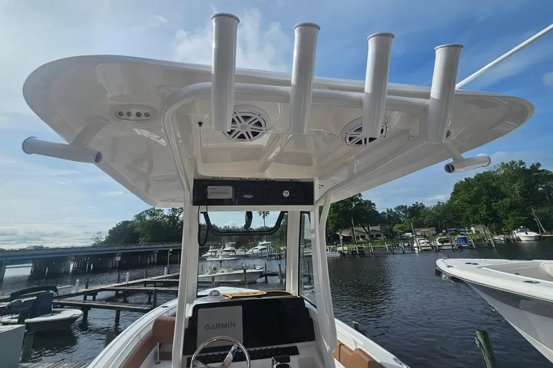 Slide: The Image of 2027 Sea Hunt Ultra 239 SE boat with T-top and rod holders at a marina. - 14