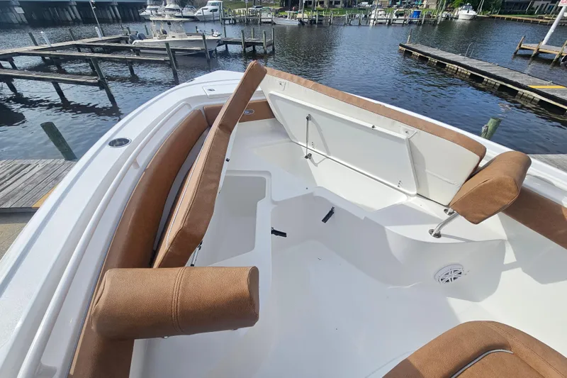 Slide: The Image of 2027 Sea Hunt Ultra 239 SE boat interior with brown seating, docked at a marina. - 26