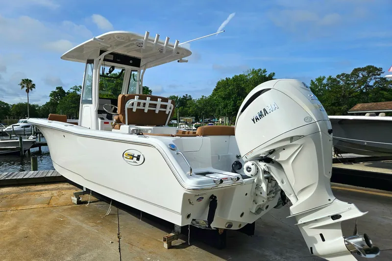 Slide: The Image of 2027 Sea Hunt Ultra 239 SE boat with Yamaha outboard motor at a marina. - 3