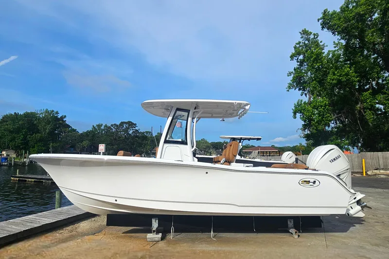 Slide: The Image of 2027 Sea Hunt Ultra 239 SE boat docked, featuring sleek design and Yamaha engine. - 2