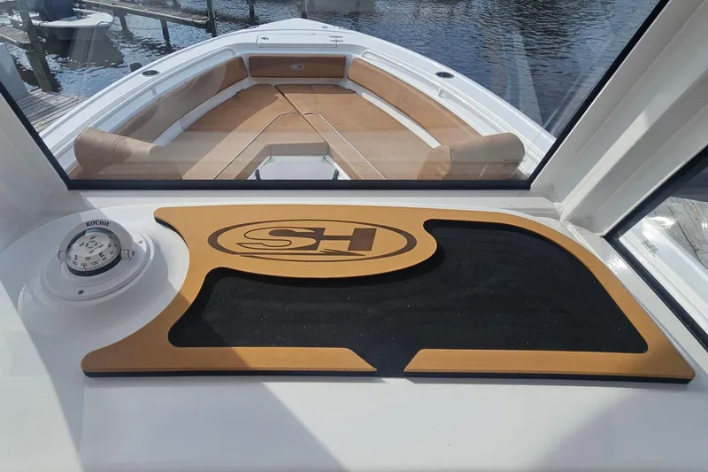 Slide: The Image of 2027 Sea Hunt Ultra 239 SE boat interior with compass and logo mat. - 21