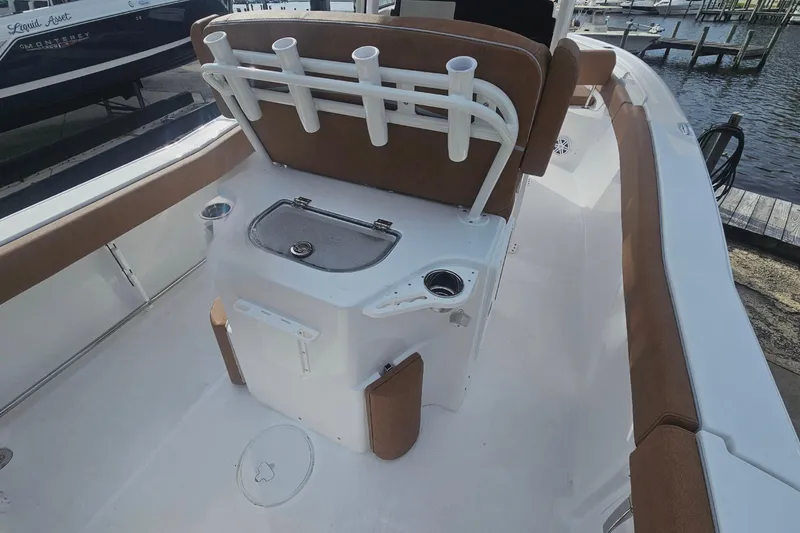 Slide: The Image of 2027 Sea Hunt Ultra 239 SE boat interior with seating and fishing rod holders. - 13