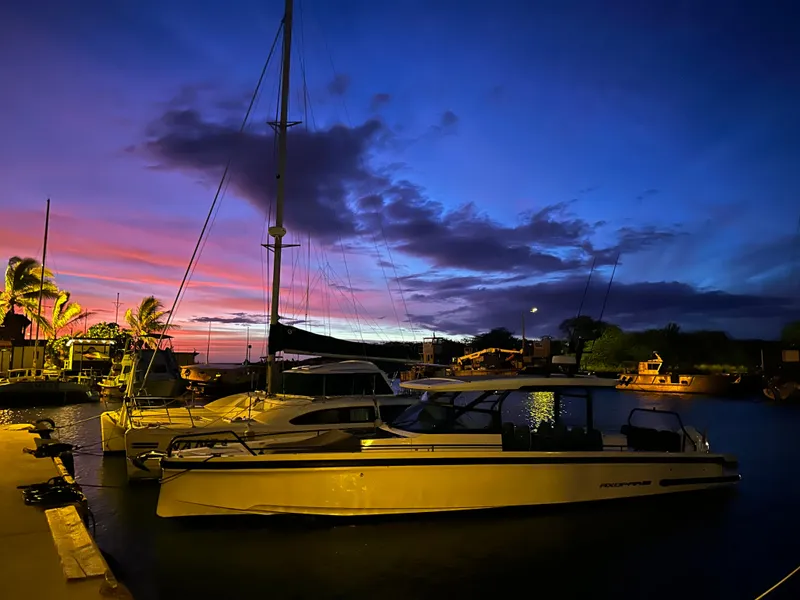Slide: The Image of A 2021 Axopar 37 Sun-Top docked at sunset, surrounded by palm trees. - 15