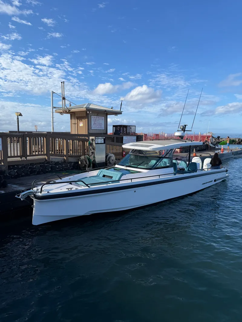 Slide: The Image of A 2021 Axopar 37 Sun-Top boat docked. It features a sleek design and open cabin. - 9