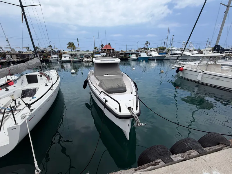 Slide: The Image of A 2021 Axopar 37 Sun-Top is docked in a busy harbor, surrounded by other boats. - 1