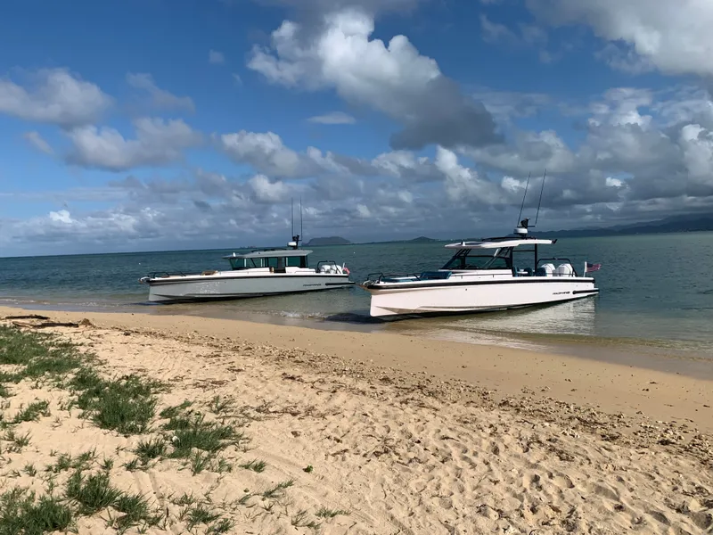 Slide: The Image of Two modern boats are beached on a sandy shore with a blue sky and calm sea in the background. - 6