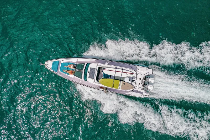 Slide: The Image of A 2021 Axopar Brabus 37 Sun-Top speeds across turquoise water. - 1