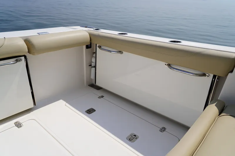 Slide: The Image of The image shows the cockpit of a 2015 Pursuit DC 325 Dual Console boat with beige upholstery. - 45