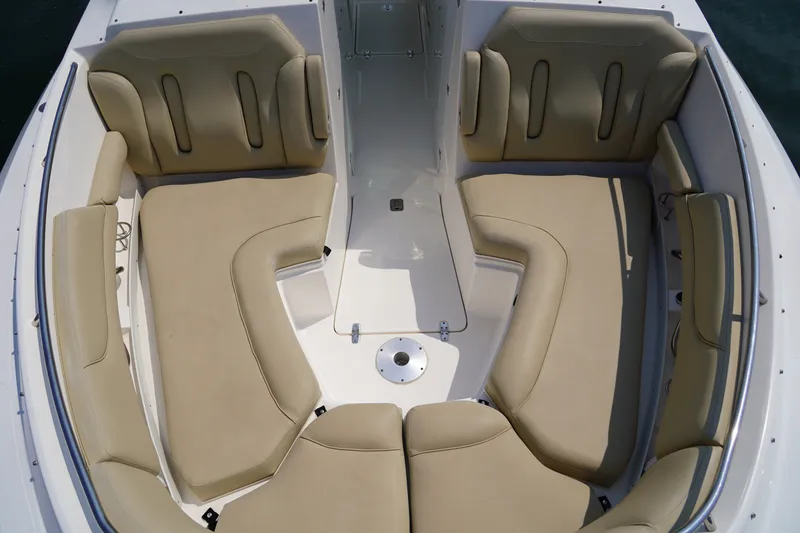 Slide: The Image of The image shows the bow area of a Pursuit DC 325 Dual Console boat with beige cushions. - 39