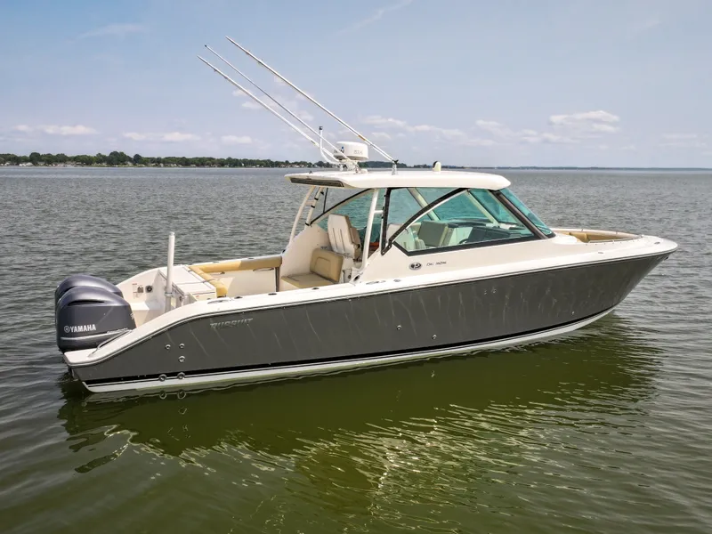 Slide: The Image of A 2015 Pursuit DC 325 Dual Console boat on calm water. - 9