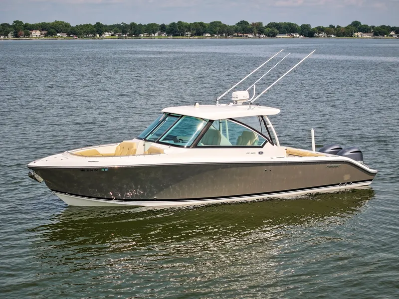 Slide: The Image of A 2015 Pursuit DC 325 Dual Console boat on calm water, featuring twin outboard engines. - 18
