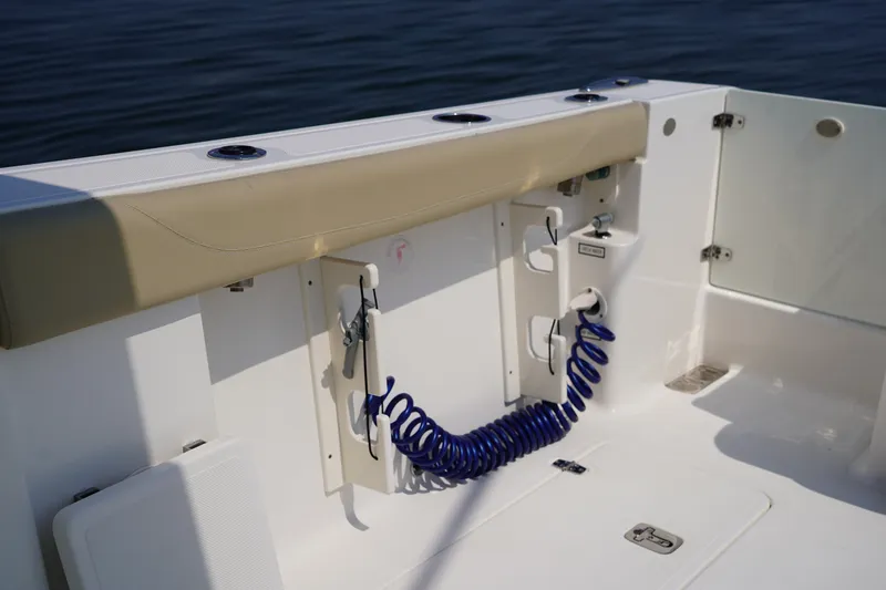 Slide: The Image of The image shows the cockpit of a 2015 Pursuit DC 325 Dual Console with a blue washdown hose. - 44