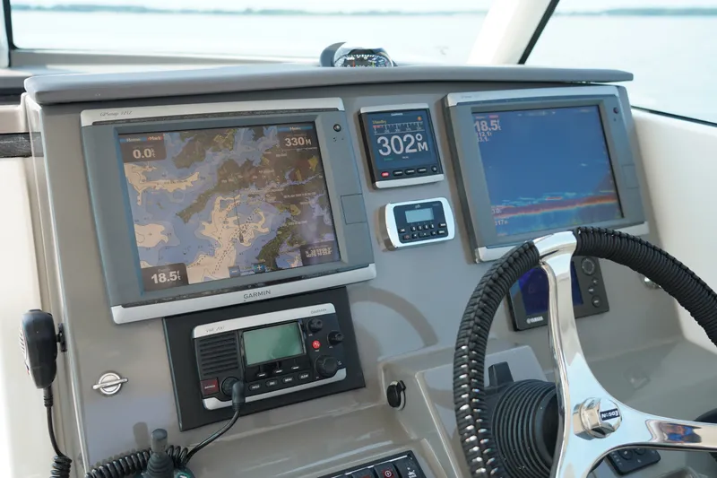 Slide: The Image of The image shows the dashboard of a Pursuit DC 325 Dual Console boat with navigation screens. - 49
