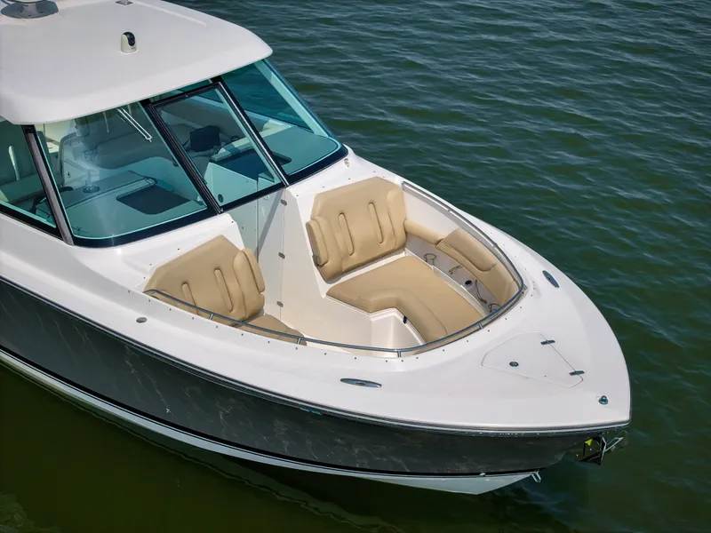 Slide: The Image of A sleek boat with beige cushioned seating area at the bow, floating on calm water. - 27
