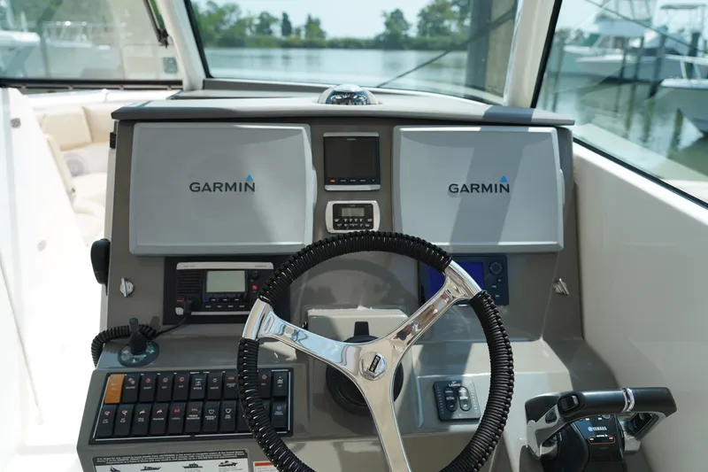 Slide: The Image of The image shows the helm of a 2015 Pursuit DC 325 Dual Console boat with Garmin electronics. - 37
