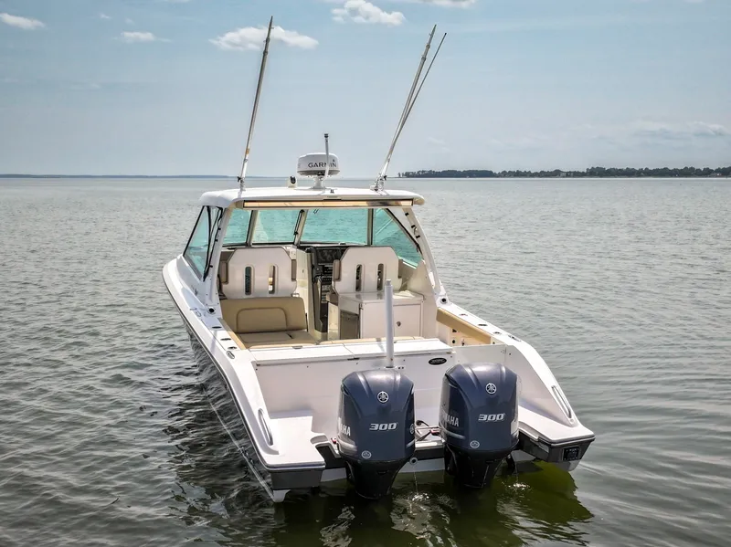 Slide: The Image of A 2015 Pursuit DC 325 Dual Console boat on calm water with two outboard engines. - 13