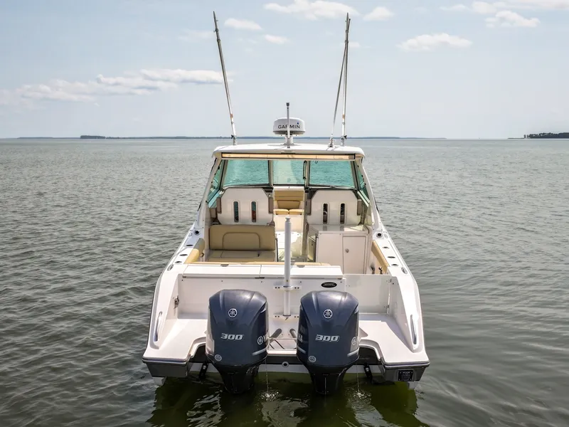 Slide: The Image of A 2015 Pursuit DC 325 Dual Console boat on calm water with two outboard engines. - 12