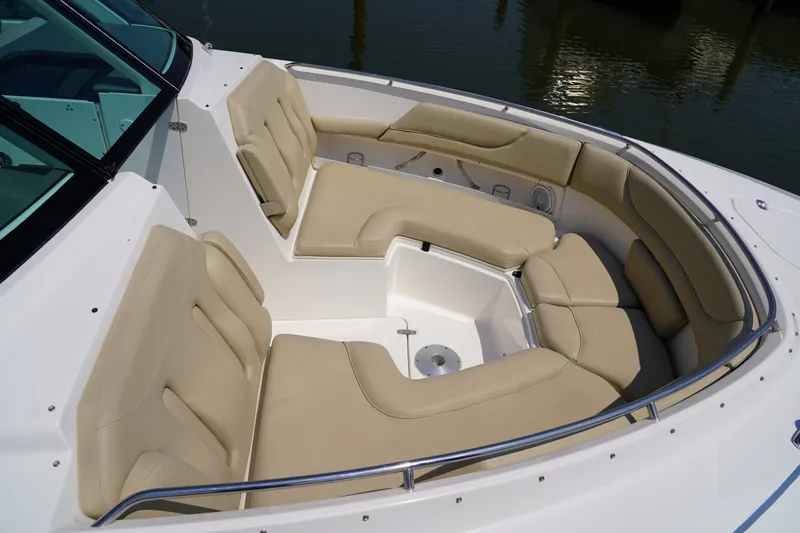 Slide: The Image of The image shows the bow area of a Pursuit DC 325 Dual Console boat with beige upholstery. - 36