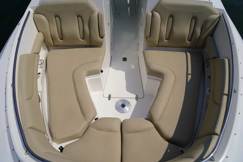 Slide: The Image of The image shows the bow area of a Pursuit DC 325 Dual Console boat with beige cushions. - 42