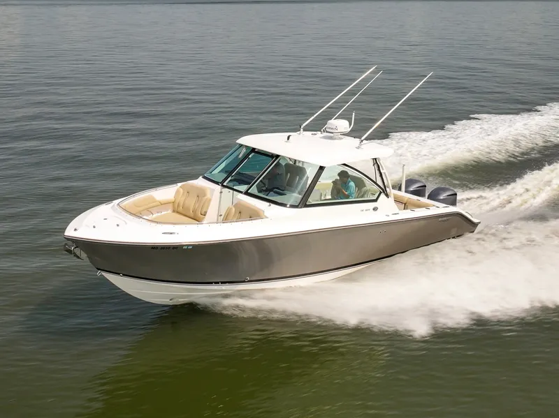 Slide: The Image of A 2015 Pursuit DC 325 Dual Console boat speeding across calm water. - 2