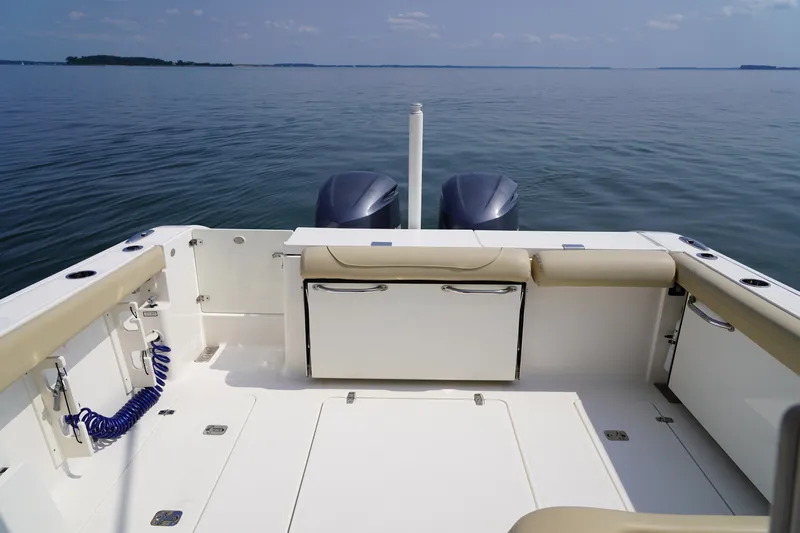 Slide: The Image of The image shows the stern of a 2015 Pursuit DC 325 Dual Console boat on calm water. - 43