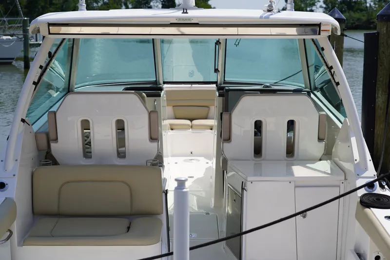 Slide: The Image of The image shows the cockpit of a 2015 Pursuit DC 325 Dual Console with beige seating. - 34