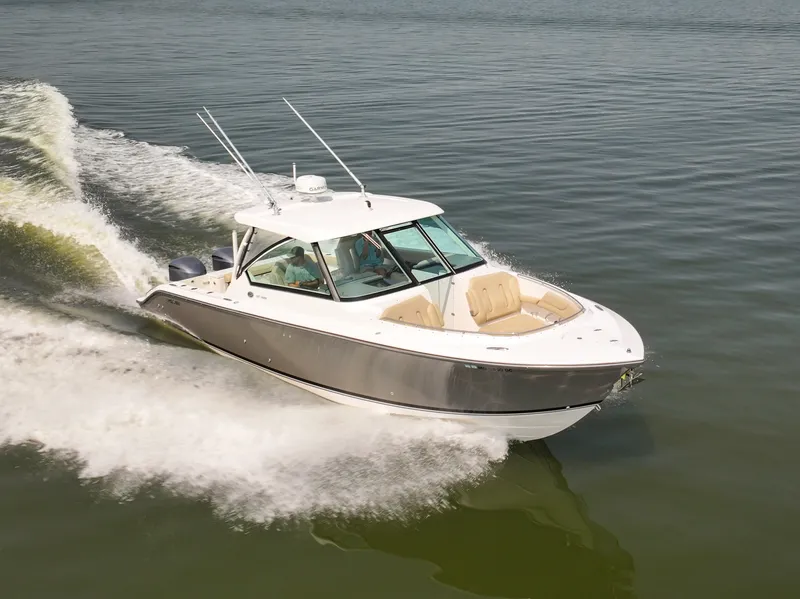 Slide: The Image of A 2015 Pursuit DC 325 Dual Console boat speeding across calm water. - 0