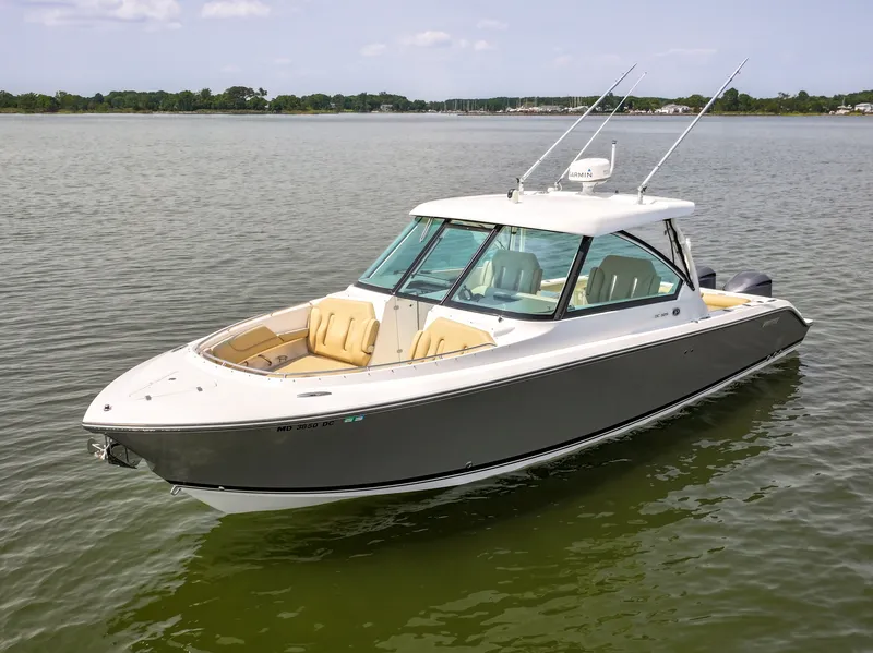 Slide: The Image of A 2015 Pursuit DC 325 Dual Console boat on calm water with two outboard engines. - 21