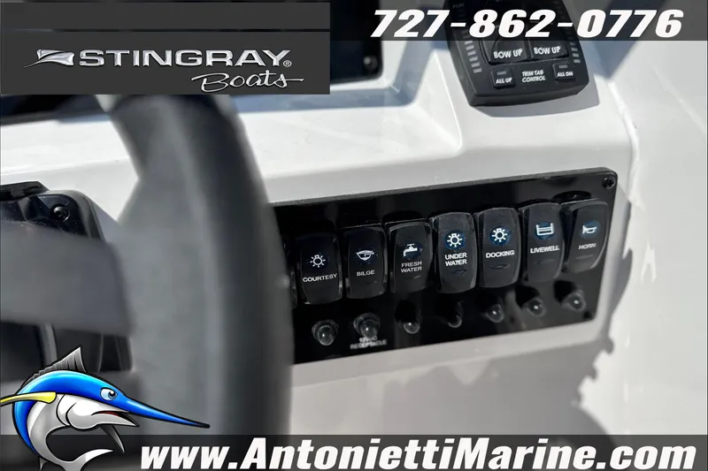 Slide: The Image of Control panel of a 2027 Stingray 24 DC boat with various switches and branding. - 22