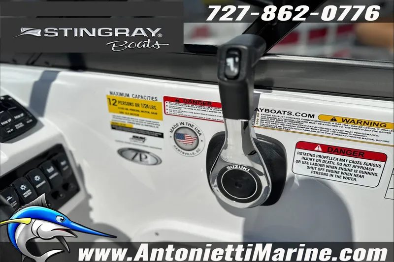 Slide: The Image of 2027 Stingray 24 DC boat dashboard with Suzuki throttle, warning labels, and contact details. - 23