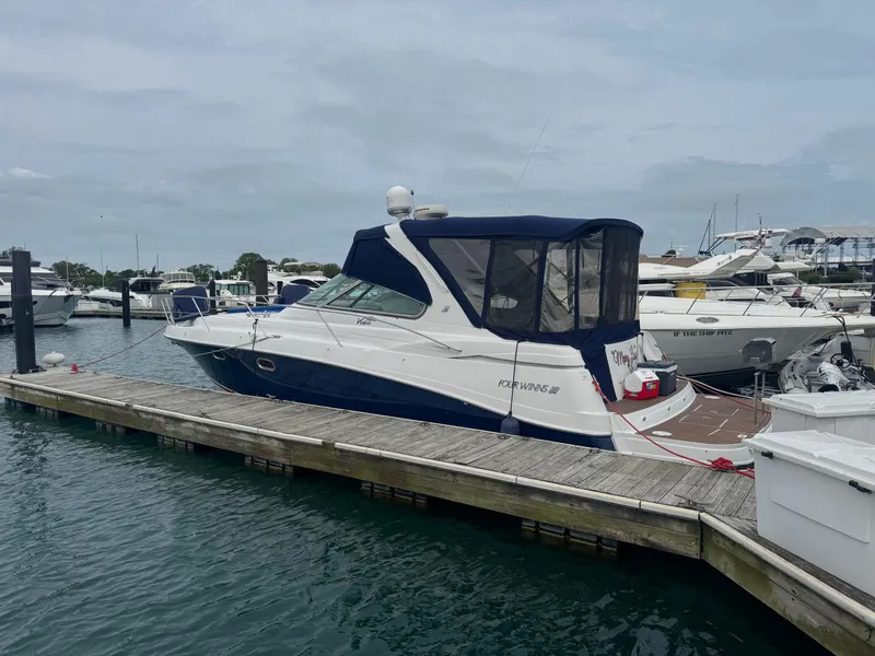 Slide: The Image of 2007 Four Winns 378 Vista yacht docked at marina, featuring sleek design and blue canopy. - 1