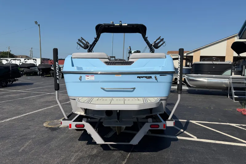 Slide: The Image of 2025 Moomba Tykon boat, light blue, parked in a marina lot under clear skies. - 3