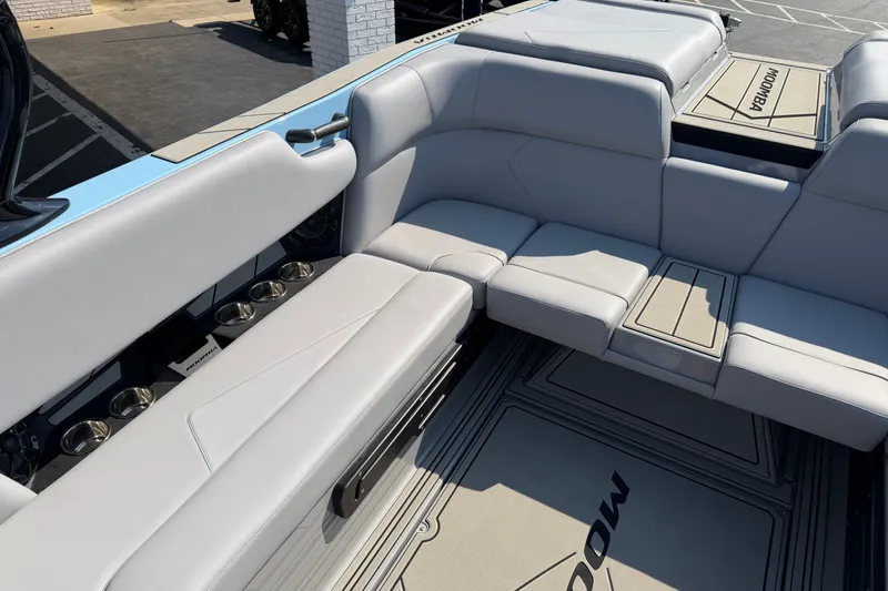 Slide: The Image of 2025 Moomba Tykon boat interior with gray seating and cup holders. - 8