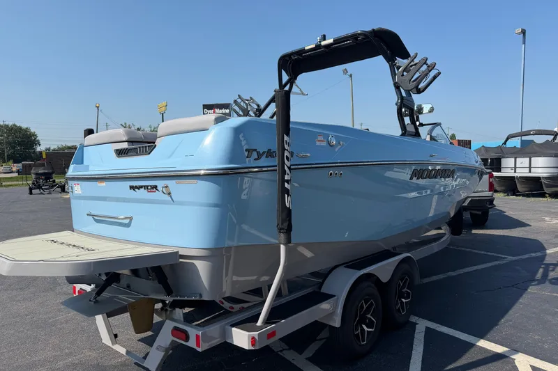 Slide: The Image of 2025 Moomba Tykon boat in light blue on trailer, parked outdoors. - 4