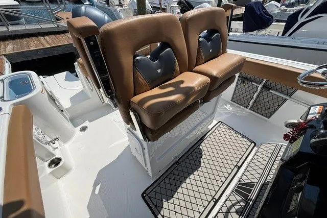 Slide: The Image of 2021 Wellcraft 242 Fisherman boat interior with brown cushioned seats and storage nets. - 16