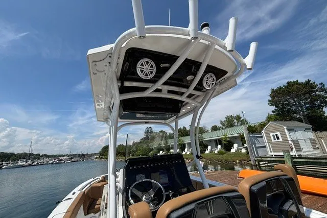 Slide: The Image of 2021 Wellcraft 242 Fisherman boat interior with steering console and overhead speakers. - 13