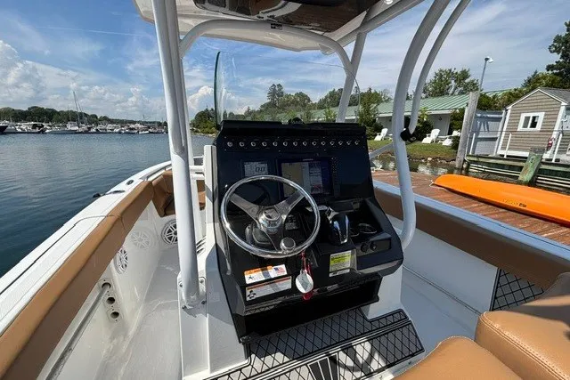 Slide: The Image of 2021 Wellcraft 242 Fisherman boat cockpit with steering wheel and control panel. - 12