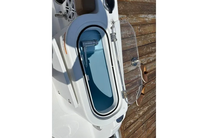 Slide: The Image of Open storage compartment on 2021 Wellcraft 242 Fisherman boat, featuring a transparent lid. - 24