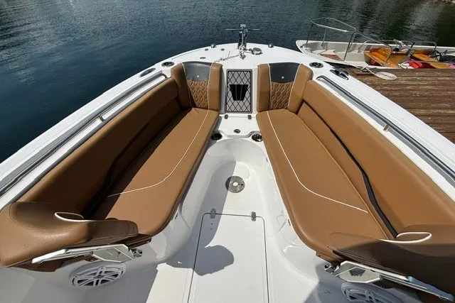 Slide: The Image of 2021 Wellcraft 242 Fisherman boat interior with tan seating, docked by the water. - 6
