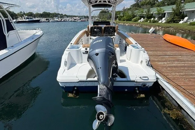 Slide: The Image of 2021 Wellcraft 242 Fisherman boat docked, featuring powerful outboard motor. - 4