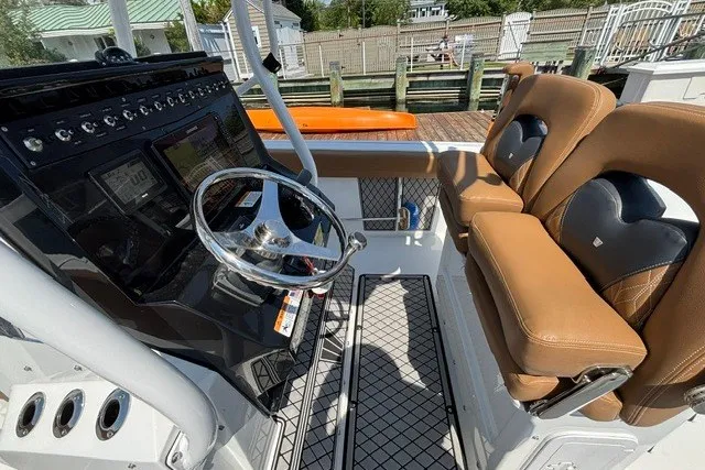Slide: The Image of 2021 Wellcraft 242 Fisherman boat interior with steering wheel and cushioned seats. - 14