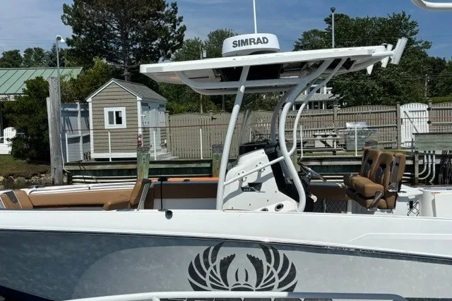Slide: The Image of 2021 Wellcraft 242 Fisherman boat docked, featuring Simrad electronics and stylish seating. - 5